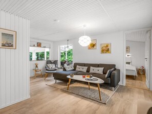 A modern living room with a sofa, coffee table, and artwork on the walls.