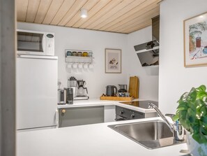 A modern kitchen with a built-in microwave, coffee maker, and toaster.