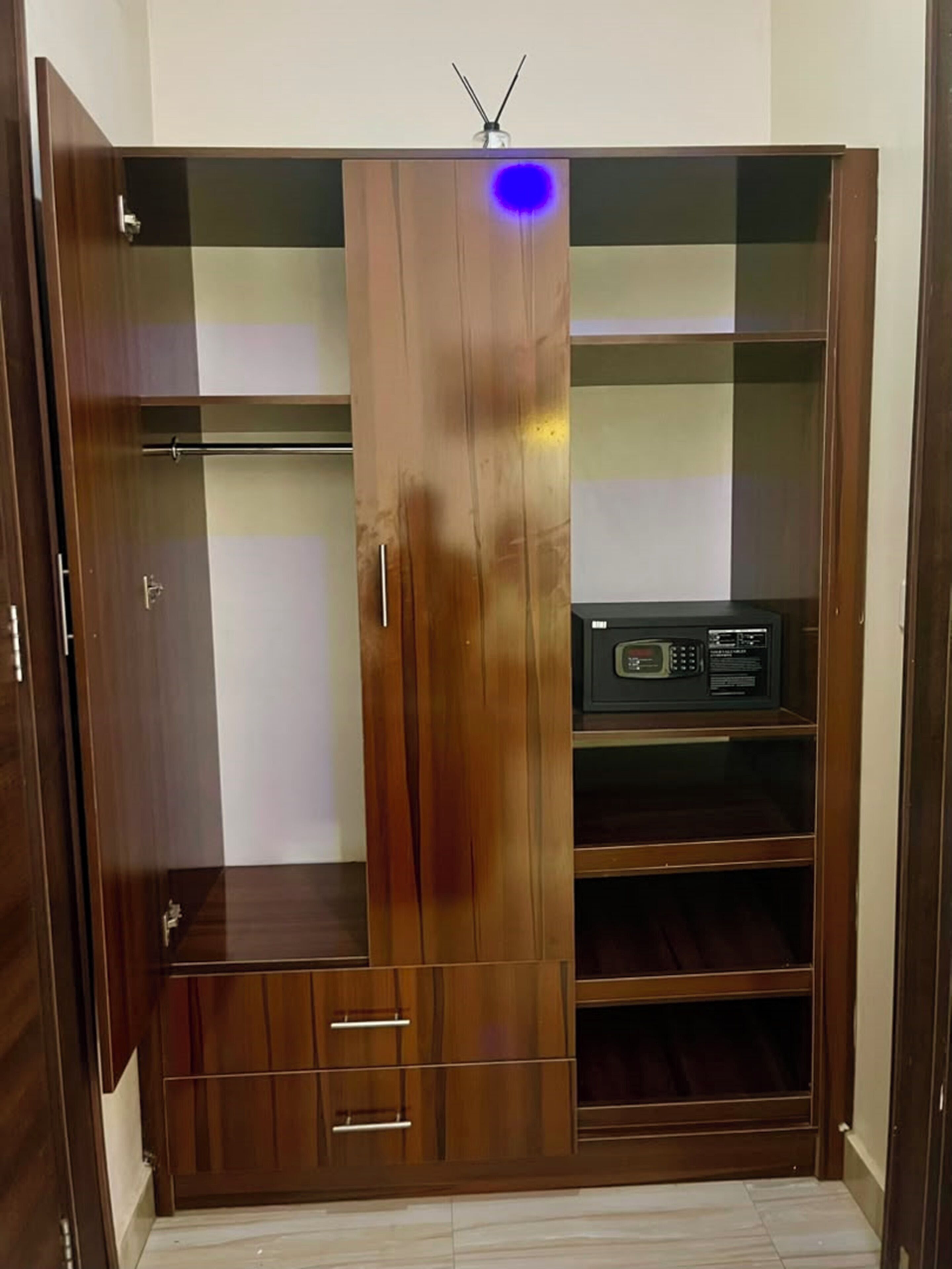 A wooden wardrobe with multiple shelves and a radio.