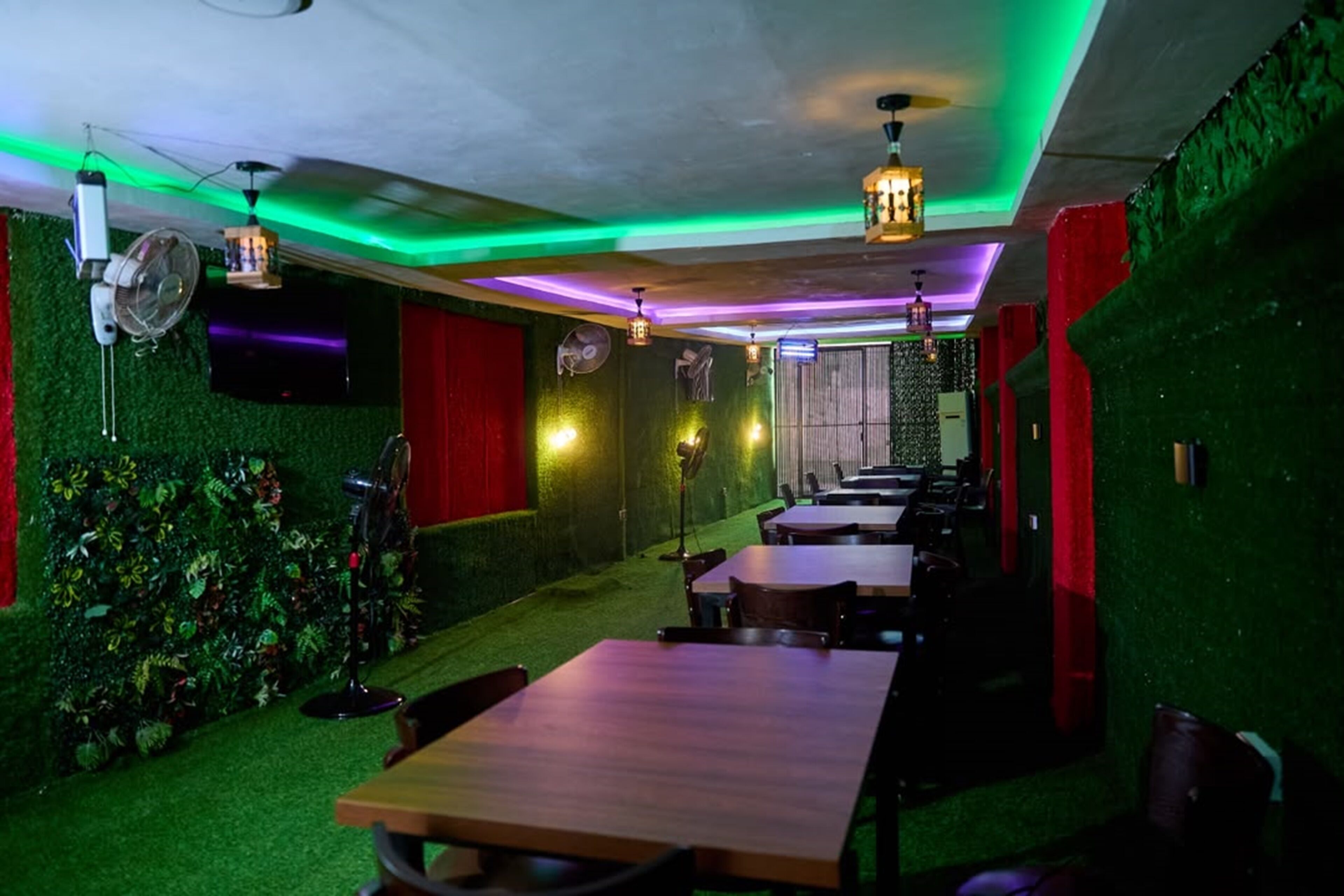 A room with a green wall, a red curtain, and a wooden table.