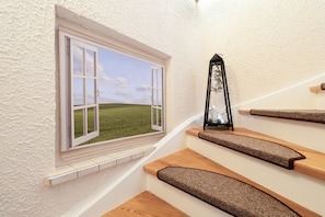 A staircase with a window opening to a grassy field. - Apartment 'Ferienwohnung Am Hasepäddel' with Balcony and Wi-Fi (Fischbach bei Dahn)