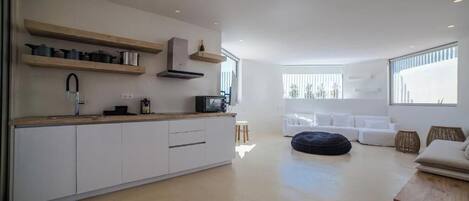 Una cocina moderna con armarios blancos, repisas de madera y una estufa integrada.