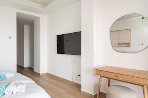 A hotel room with a bed, a wooden desk, a television, and a mirror. - Moana 4 - Luxury Home with Private Pool (Benalmádena)