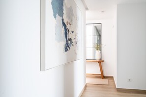 A hallway with a large abstract painting, a wooden easel, and a potted plant. - Moana 4 - Luxury Home with Private Pool (Benalmádena)