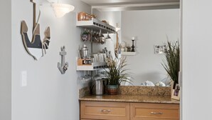 Eine Küche mit Holzschränken, einer Granit Arbeitsplatte, einer Pendelleuchte sowie verschiedenen Küchenutensilien und Dekorationen.