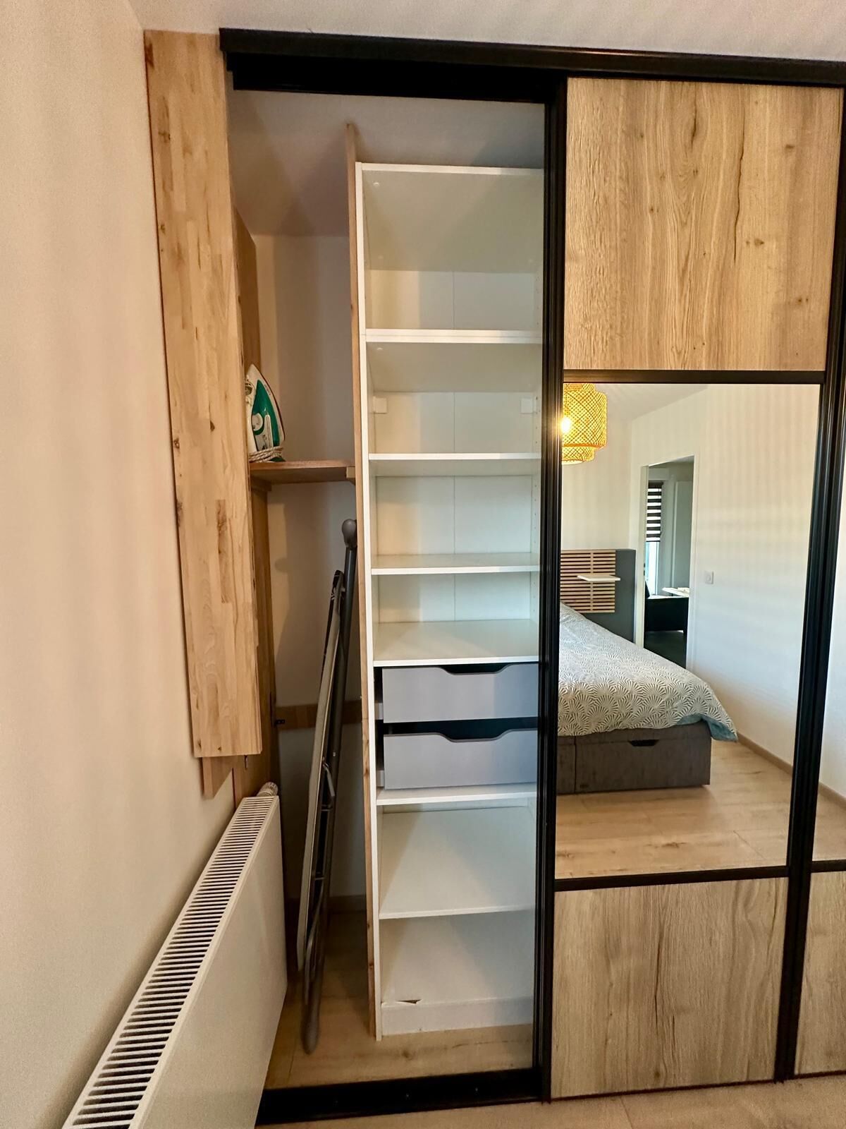 Una camera da letto con un letto, un armadio e un termosifone.