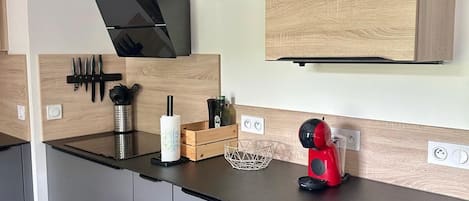 Uma cozinha moderna com eletrodomésticos embutidos, armários de madeira e um refrigerador de vinhos.