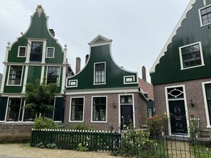 Une rangée de maisons traditionnelles néerlandaises, avec des toits à pignon et des éléments décoratifs blancs.