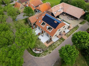 Una vista aerea di un quartiere residenziale con case dotate di tetti in tegole rosse e pannelli solari.