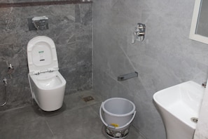 Un bany amb vàter, bidet, galleda i banyera.