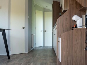 Ein Flur mit einem Holzschrank, einem weißen Heizkörper und einer Tür zu einem anderen Zimmer.