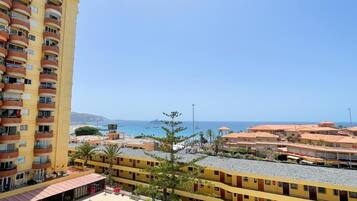 Hotel frente al mar con varios balcones, piscina y vista al mar y embarcaciones.