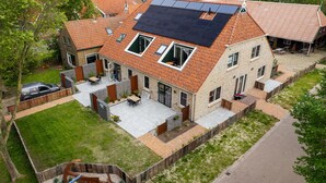 A residential property with a sloped roof, solar panels, a fenced garden, and a swimming pool. - De Witte Brugh- 't Fennoat by Interhome (Buren FR)