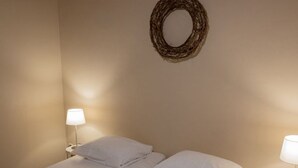 A hotel room with a bed, two bedside lamps, and a wall-mounted wreath. - Recreatieboerderij Tergracht - t Schob by Interhome (Epen)