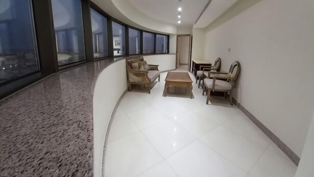 A spacious hallway with seating areas and large windows.
