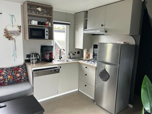 A compact kitchen with a microwave, coffee maker, and a refrigerator. - Beach Resort Kamperland - 622 by Interhome (Kamperland)