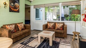 Ein Wohnzimmer mit zwei Sofas, einem Couchtisch, einem Gemälde und einer Wanduhr.