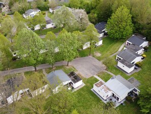 An aerial view of a residential area with detached houses, green lawns, and trees. - Bungalowpark Simpelveld - Schakel 23 by Interhome (Simpelveld)