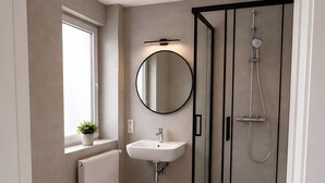 Une salle de bain moderne équipée de toilettes, d’un lavabo et d’une douche.