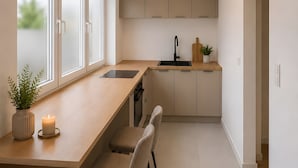 A modern kitchen with a central island, built-in cabinets, and a window providing natural light.