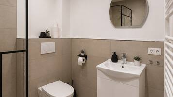 Une salle de bain moderne avec des toilettes, un lavabo et un miroir.