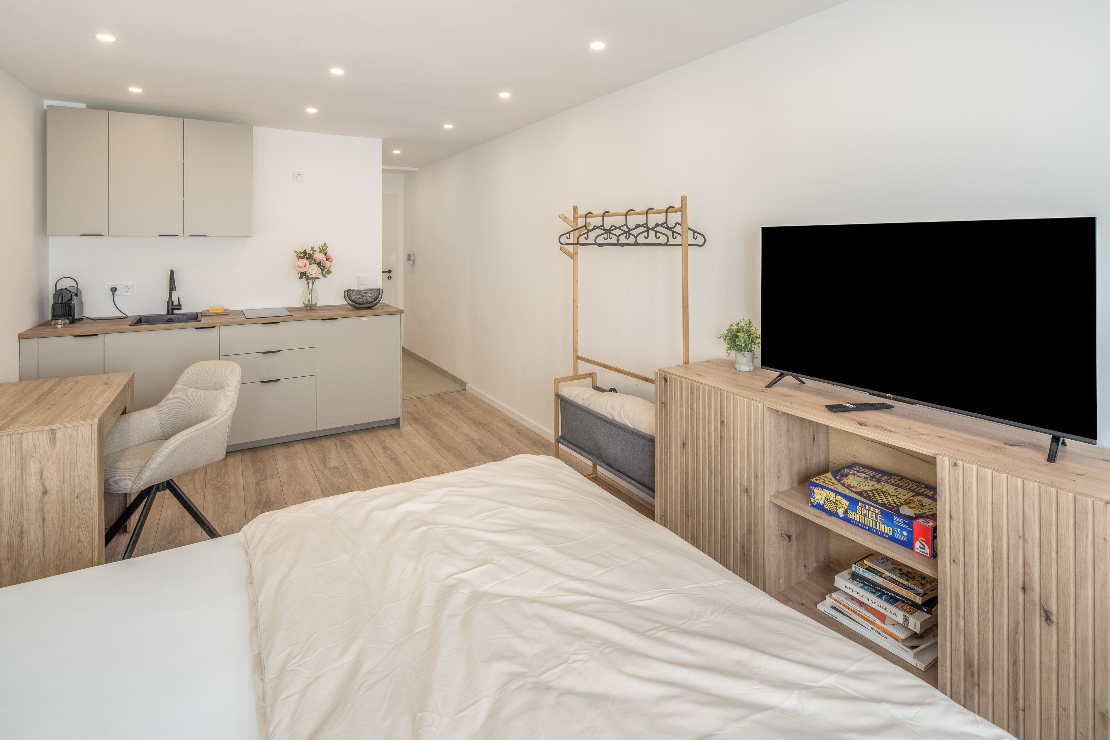 Une chambre à coucher moderne, équipée d’un lit, d’un bureau, d’une télévision et d’une bibliothèque.