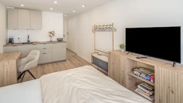 Une chambre à coucher moderne, équipée d’un lit, d’un bureau, d’une télévision et d’une bibliothèque.