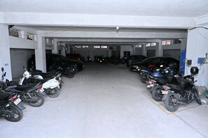 A multi-level parking garage with various vehicles including cars and motorcycles.