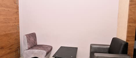 Un cuarto pequeño y cerrado con dos sillas y una mesa pequeña.