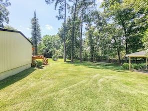 A backyard with a wooden deck, a covered patio, and a well-maintained lawn. - 5 bedrooms 3bath Cozy Home (Warner Robins)