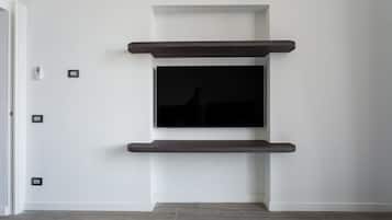 Ein modernes Interieur mit einem wandmontierten Flachbildfernseher, der von zwei dunklen Holzbögen begleitet wird.