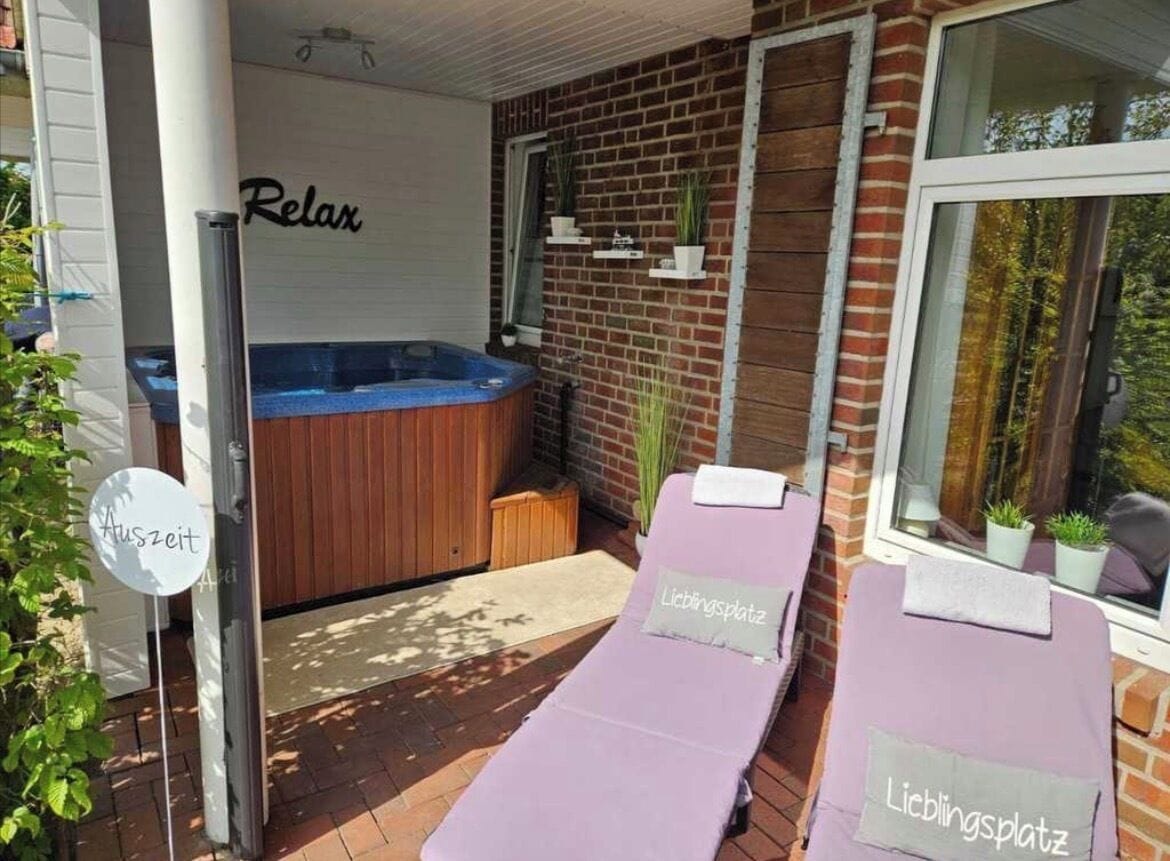 Un espacio de spa con una bañera de hidromasaje, dos sillones de masaje y un cartel de relajación.