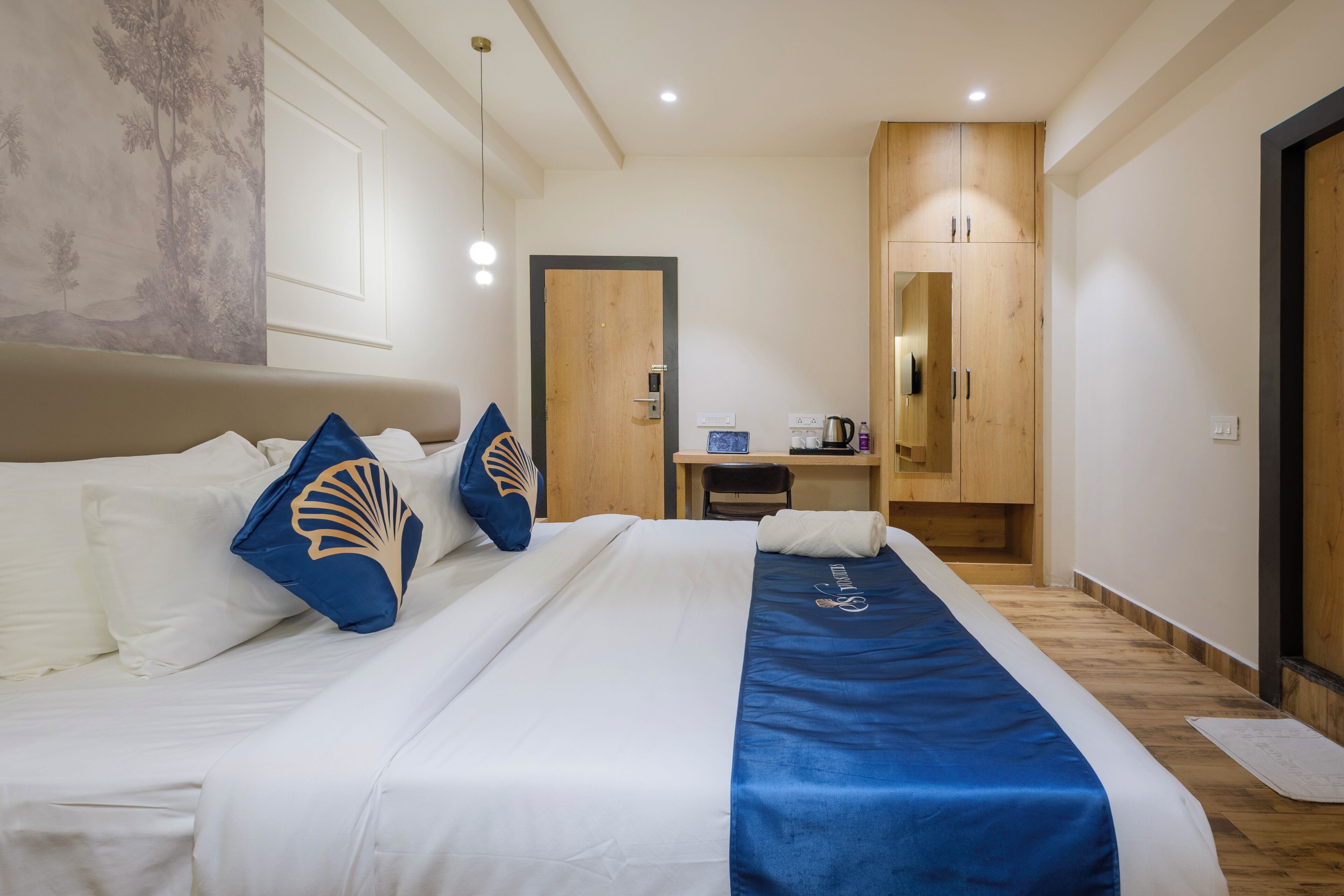Een hotelkamer met een bed, een bureau en een kledingkast.