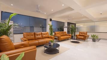 Una sala de estar moderna con sofás de cuero, una mesa de centro y plantas en macetas.