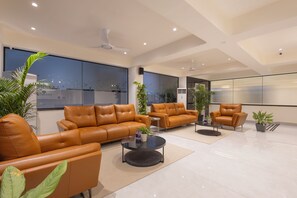 A modern living room with leather sofas, a coffee table, and potted plants. - Elvo Suites, Madhapur - HITEC City, Hyderabad (Hyderabad)