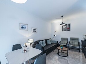 A modern living room with a sofa, chairs, a dining table, and artwork on the walls. - Medina Torrecilla Beach by Casasol by Interhome (Nerja)