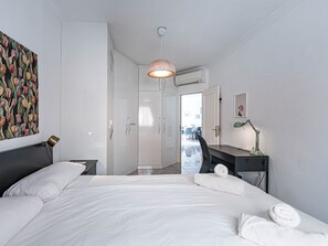 A modern hotel room with a large bed, a desk, a chair, a desk lamp, and a painting on the wall. - Medina Torrecilla Beach by Casasol by Interhome (Nerja)