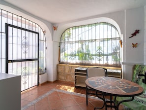 A room with a curved window, a round table, and a chair. - Ladera del Mar 32 by Casasol by Interhome (Nerja)