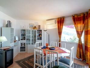 A dining area with a table, chairs, and a window with curtains. - Ladera del Mar 32 by Casasol by Interhome (Nerja)