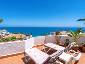 A terrace with a view of the sea, featuring a lounge chair and table. - Ladera del Mar 32 by Casasol by Interhome (Nerja)