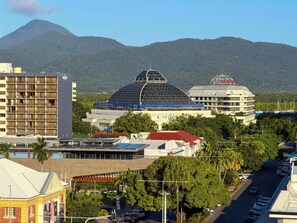 A hotel with multiple floors, a large dome structure, and a mountain in the background. - Seaview Escape—Scenic Views, Pool and Prime Location (Cairns City)