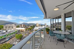 Ein Balkon mit Blick auf eine Stadtlandschaft, einschließlich Gebäude und Berge.