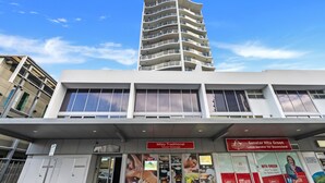 A multi-story building with a modern architectural design, featuring large windows and a flat roof.