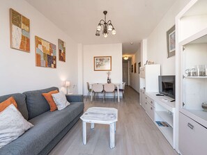 A modern living room with a grey sofa, a coffee table, and artwork on the walls. - Toboso  1C Torrecilla Beach Paradise by Casasol by Interhome (Nerja)