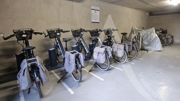 En parkeringsgarage med cykler parkeret i afmærkede parkeringsbåse.