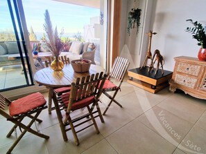 A dining area with a round table, four wooden chairs, and a vase with dried plants. - 104 / T2 RES DE STANDING, CLIM, PARKING (Sète)