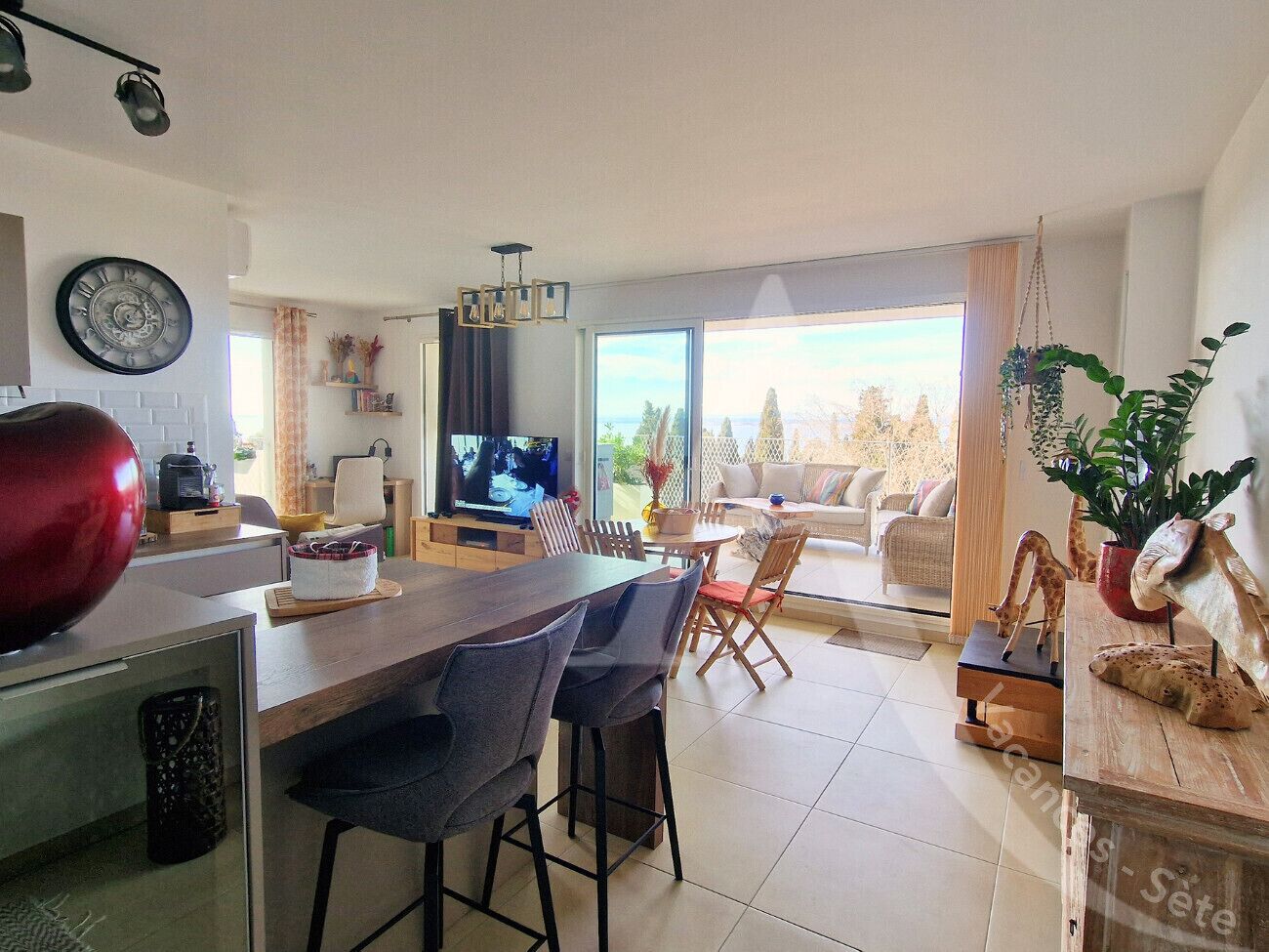 Un espacio habitable moderno con cocina, comedor y un amplio ventanal que ofrece vistas al exterior.