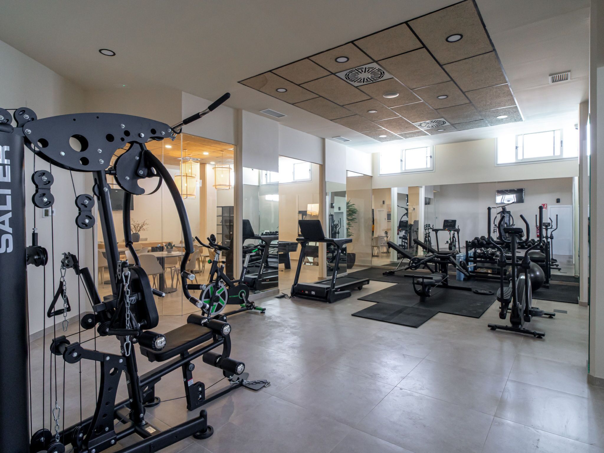 Un gimnasio con diversos equipos de ejercicio, incluyendo cintas de correr y máquinas de pesas.