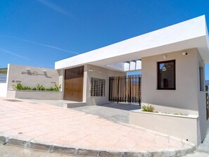 A modern building with a flat roof, a gated entrance, and a paved driveway. - Apartment  by Interhome (La Axarquía/ Torrox)