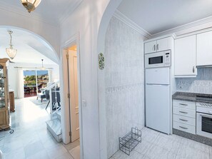 Eine moderne Küche mit weißen Schränken, einer Mikrowelle und einem eingebauten Backofen.